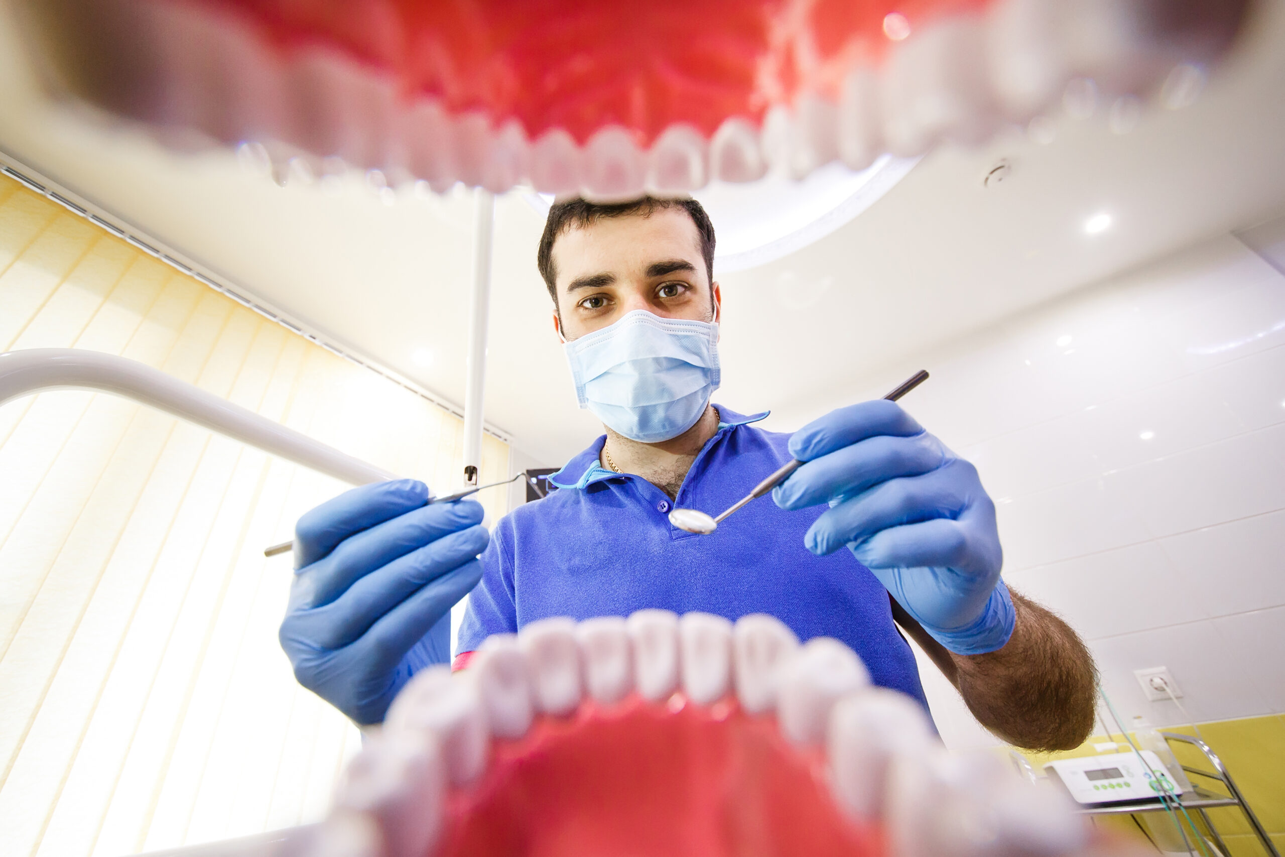 Dentista visto da perspectiva do paciente durante exame odontológico, simbolizando o atendimento humanizado na Sorridents Porto Alegre.