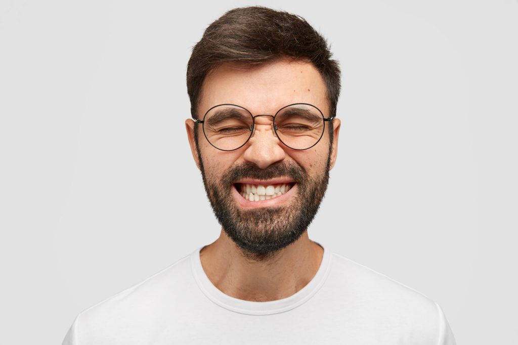 Homem sorrindo com alívio após tratamento para bruxismo na Sorridents Porto Alegre