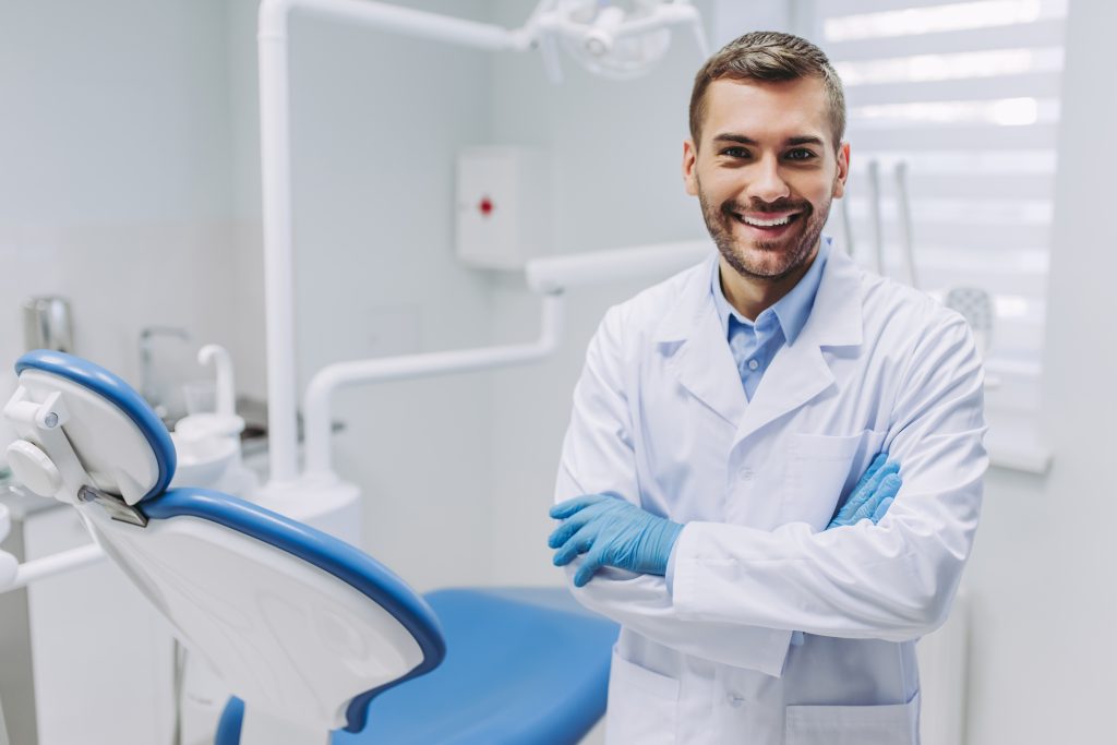 Dentista sorridente em consultório moderno, representando atendimento profissional da Sorridents Porto Alegre.